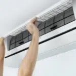 addetto di cui si vedono solo braccia e mani che controlla lo splitter di un condizionatore